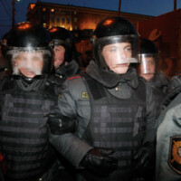 (AP, Associated Press Photo/Alexander Zemlianichenko Jr) Russian police officers, with their helmets’ protective visor frost covered, block a square where demonstrators gather for an unsanctioned opposition rally in downtown Moscow, Russia, Tuesday, Jan. 31, 2012. The Russian opposition protests on the 31st of each month are a nod to the 31st article of the Russian constitution, which guarantees the right of assembly., 2012, Inkjet on photo paper, 35” x 40”