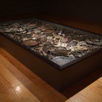 CARLOS RUNCIE TANAKA, "Manto", 1978-2006, 378 x 204 x 47 cm., Installation – glass case containing ceramic fragments, Stoneware, gas fired, 1280-1350ºC. “Textile” made of fragments of ceramic objects produced and broken between years 1978 and 2006. These fragments, broken and then reattached, are an attempt to see Peru as a country where many cultures and races meet in search of a common identity. different geographies one nation one world.