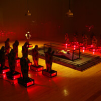 CARLOS RUNCIE TANAKA, "Tiempo detenido / No Olvidar", 1997-2006, Variable dimensions, Installation - 22 ceramic figures, 11 glass/metal cases with red light, 10 glass/metal cases containing red marbles, 1 glass/metal urn containing 1 ceramic figure and three lamps hanging from the ceiling in a room with inner walls covered completely by glass panels. Taking inspiration from his hostage experience at the Japanese Ambassador’s Residence where he was held captive with many others by the MRTA (Movimiento Revolucionario Túpac Amaru) in Lima, December 1996, the artist creates this installation with allusions to violence and the lack of communication. Time detained – Do not forget