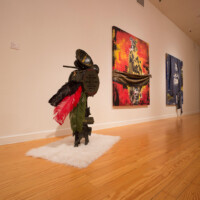 Robert Hodge, From left to right: "Auditorium", 2016, found African stools, reclaimed drum, horn and speaker, hemp thread, mardi gras feathers; "Let that mutha fucka Burn", 2016, mixed media materials on canvas; "We don’t need no water", 2016, mixed media materials on canvas